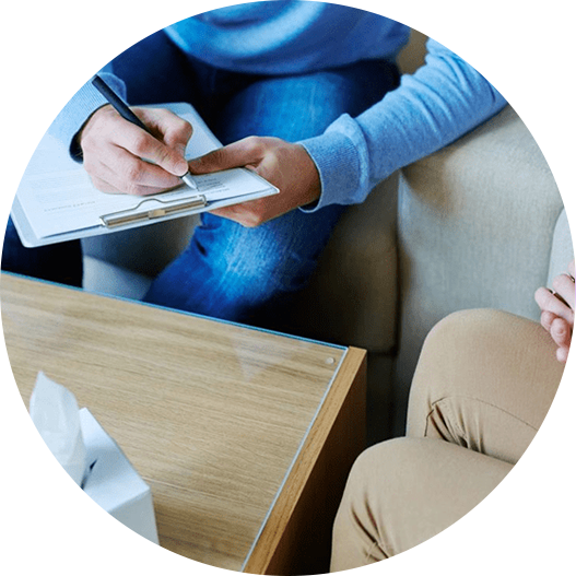 A person sitting at a table writing on paper.