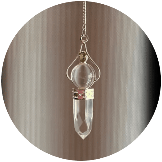 A clear glass pendulum with a gold bead.